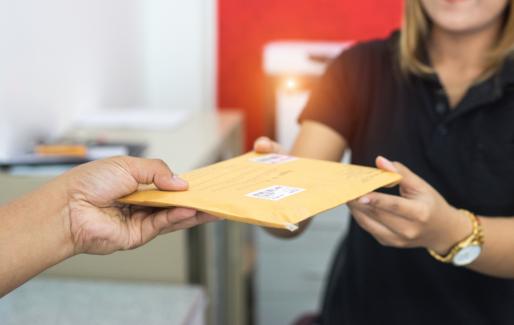 male hand send mail envelope to the female of post office before